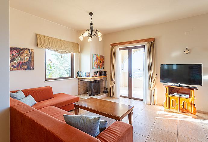 Open-plan living room with sofa, dining area, kitchen, ornamental fireplace, WiFi internet, satellite TV, DVD player, and terrace access . - Villa Selini . (Galleria fotografica) }}