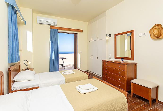 Twin bedroom with en suite bathroom, A/C, and balcony access . - Villa Selini . (Photo Gallery) }}