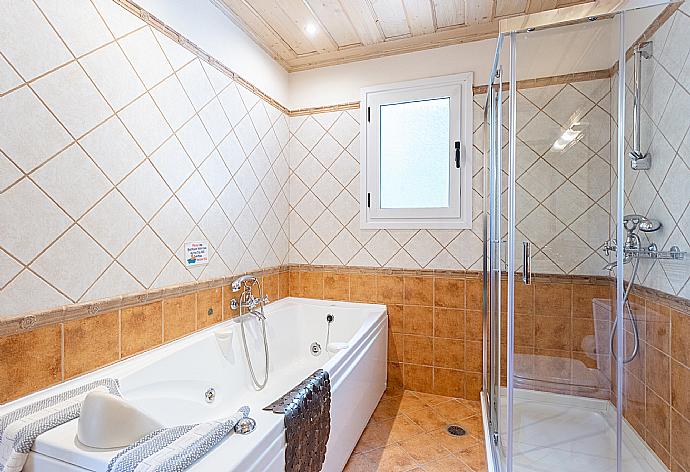 En suite bathroom with bath and shower . - Villa Emilios . (Photo Gallery) }}