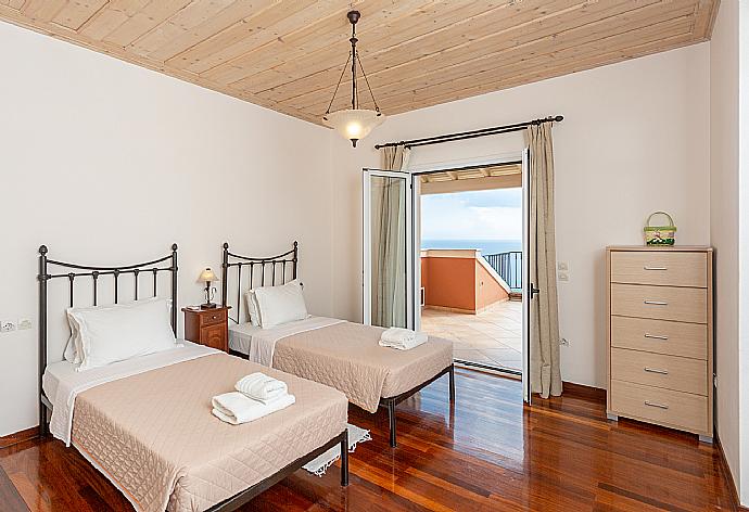 Twin bedroom with en suite bathroom, A/C, and upper terrace access with panoramic sea views . - Villa Emilios . (Fotogalerie) }}