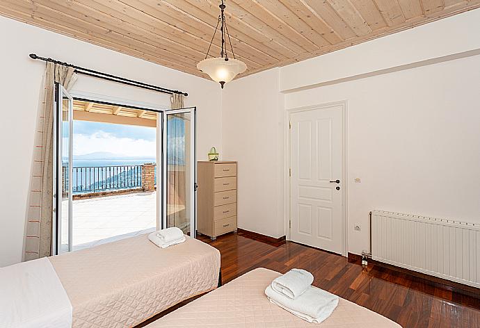 Twin bedroom with en suite bathroom, A/C, and upper terrace access with panoramic sea views . - Villa Emilios . (Fotogalerie) }}