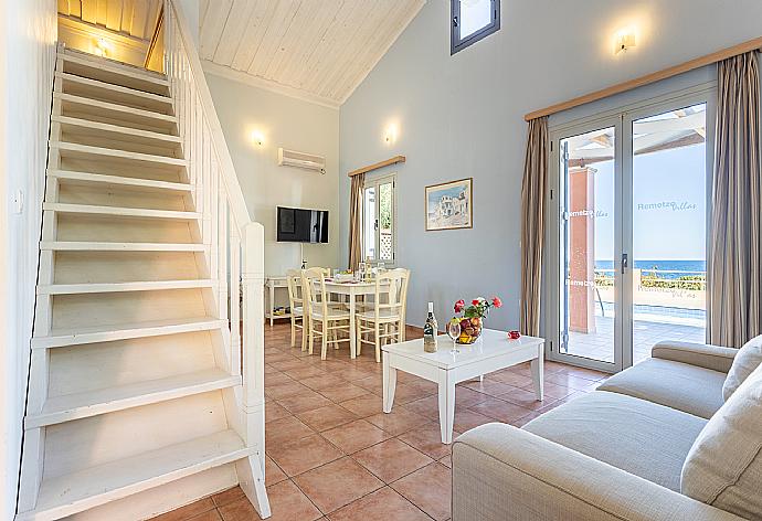 Open-plan living room with sofa, dining area, kitchen, mezzanine, A/C, WiFi internet, satellite TV, sea views, and terrace access . - Maria Beach House . (Fotogalerie) }}