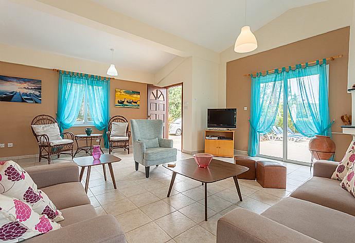 Open-plan living room with sofas, dining area, kitchen, ornamental fireplace, WiFi internet, satellite TV, DVD player, and pool terrace access . - Villa Christia Maris . (Fotogalerie) }}