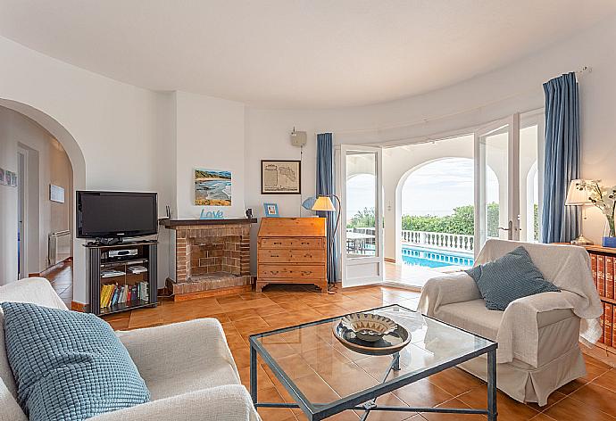 Living room with sofas, WiFi internet, TV, DVD player, ornamental fire place, and pool terrace access  . - Villa Caprice . (Galerie de photos) }}