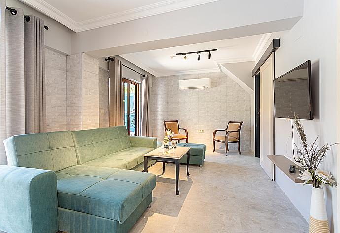 Open-plan living room with sofa, dining area, kitchen, A/C, WiFi internet, satellite TV, and terrace access . - Villa Emel Paradise . (Галерея фотографий) }}