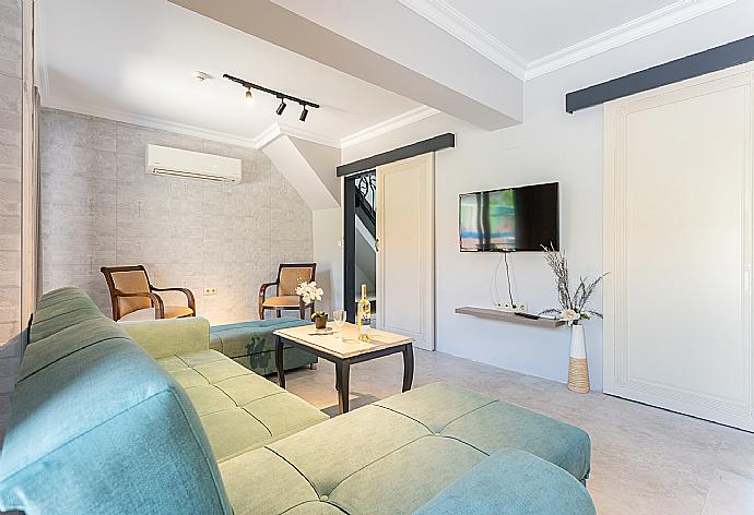 Open-plan living room with sofa, dining area, kitchen, A/C, WiFi internet, satellite TV, and terrace access . - Villa Emel Paradise . (Галерея фотографий) }}