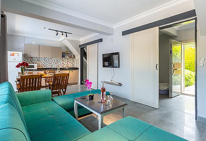 Open-plan living room with sofa, dining area, kitchen, A/C, WiFi internet, satellite TV, and terrace access . - Villa Ayla Paradise . (Galleria fotografica) }}