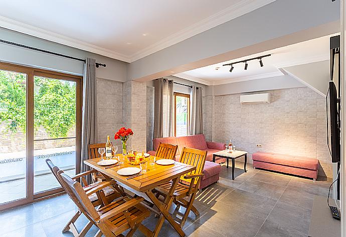 Open-plan living room with sofa, dining area, kitchen, A/C, WiFi internet, satellite TV, and terrace access . - Villa Kelebek Paradise . (Fotogalerie) }}