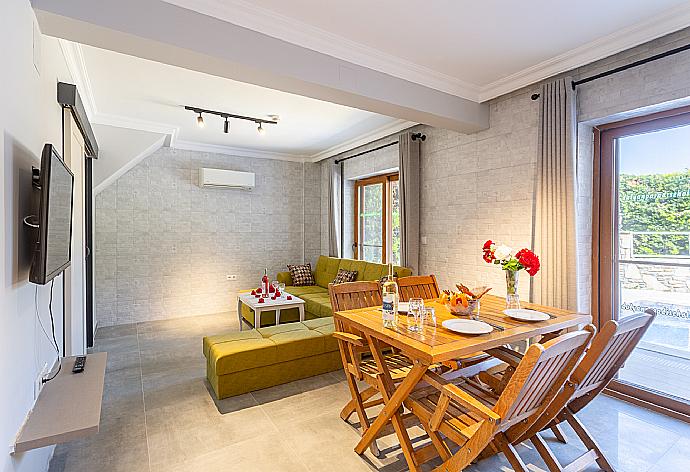 Open-plan living room with sofa, dining area, kitchen, A/C, WiFi internet, satellite TV, and terrace access . - Villa Aysel Paradise . (Photo Gallery) }}