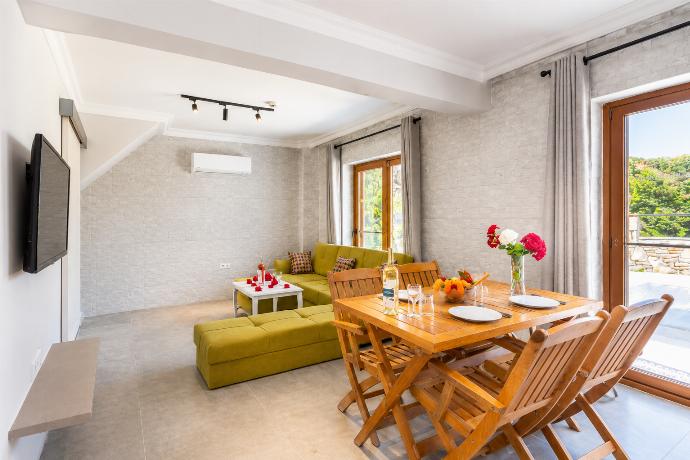 Open-plan living room with sofa, dining area, kitchen, A/C, WiFi internet, satellite TV, and terrace access . - Villa Aysel Paradise . (Γκαλερί Φωτογραφιών) }}
