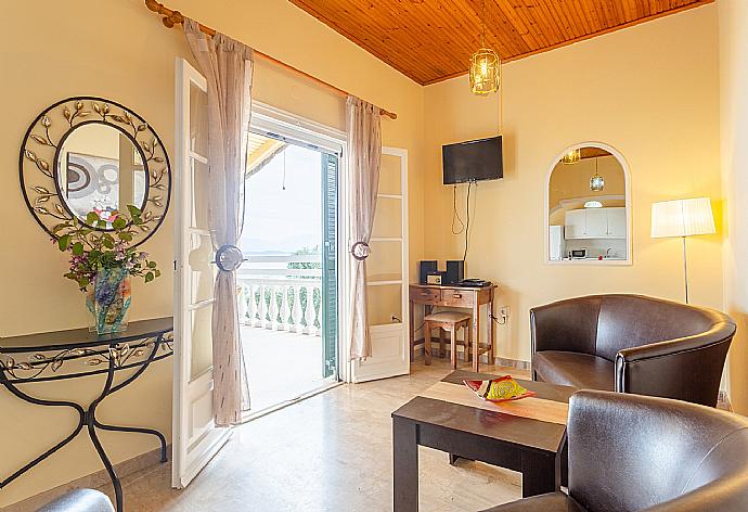 Open-plan living room with sofas, dining area, kitchen, WiFi internet, satellite TV, DVD player, and balcony access with sea views . - Villa Thespina . (Γκαλερί Φωτογραφιών) }}