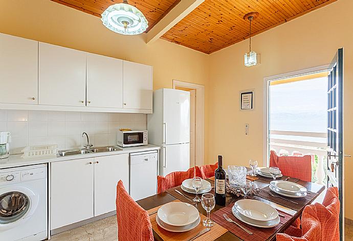 Open-plan living room with sofas, dining area, kitchen, WiFi internet, satellite TV, DVD player, and balcony access with sea views . - Villa Thespina . (Γκαλερί Φωτογραφιών) }}