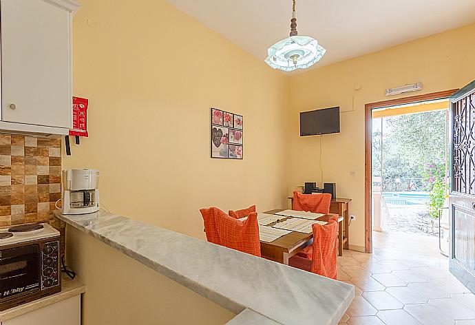Living area with dining area, kitchen, TV, and terrace access . - Villa Thespina . (Γκαλερί Φωτογραφιών) }}