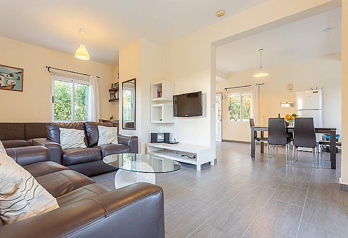 Open-plan living room with sofas, dining area, kitchen, A/C, WiFi internet, satellite TV, and pool terrace access . - Sun Beach Villa Tria . (Fotogalerie) }}