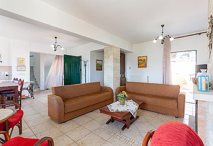 Open-plan living room with sofas, dining area, kitchen, ornamental fireplace, WiFi internet, satellite TV, DVD player, and upper terrace access . - Villa Zeus . (Fotogalerie) }}