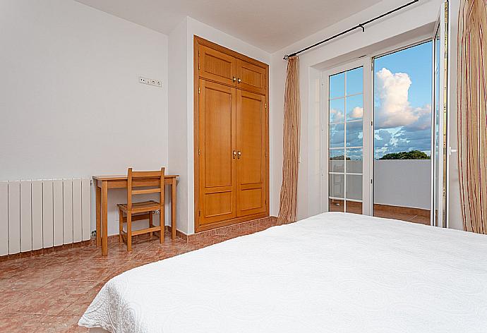 Twin bedroom with en suite bathroom and balcony access . - Villa Biniparrell . (Fotogalerie) }}