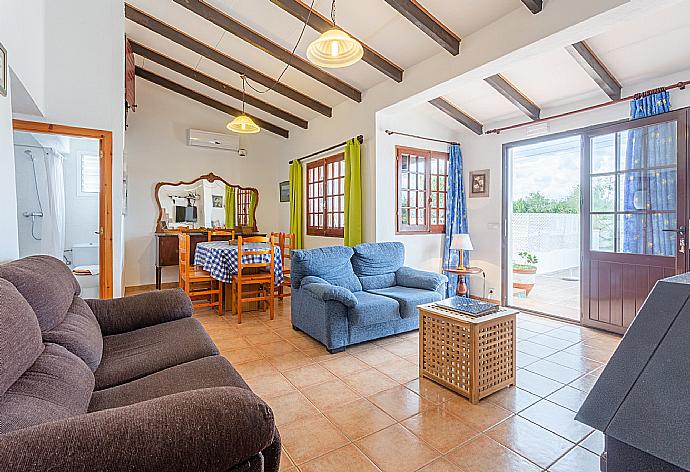 Living room with sofas, dining area, ornamental fireplace, A/C, WiFi internet, satellite TV, DVD player, and pool terrace access . - Villa Ca Nostra . (Galería de imágenes) }}