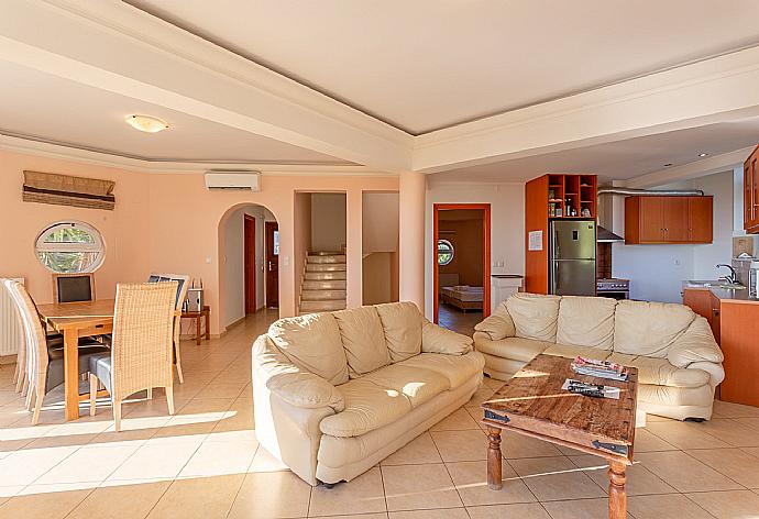 Open-plan living room on first floor with sofas, dining area, kitchen, A/C, WiFi internet, TV, DVD player, and balcony and pool terrace access . - Villa Pelagos . (Photo Gallery) }}