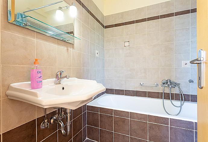 En suite bathroom with bath and overhead shower . - Villa Olympia . (Photo Gallery) }}