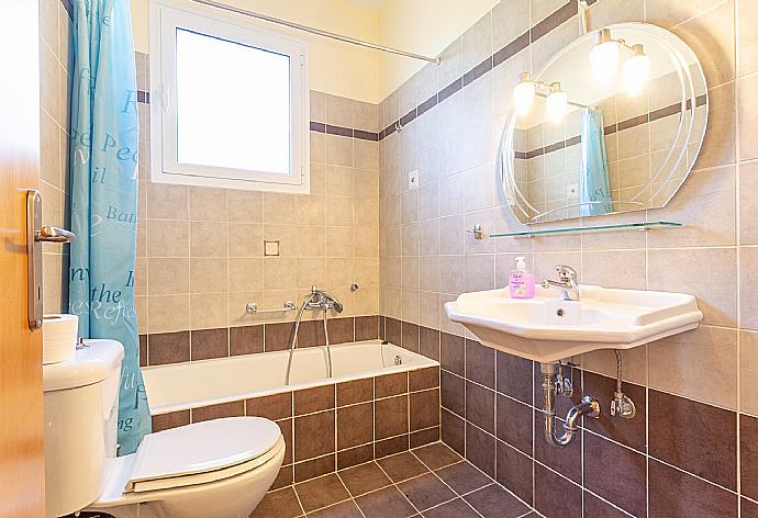 En suite bathroom with bath and overhead shower . - Villa Olympia . (Photo Gallery) }}