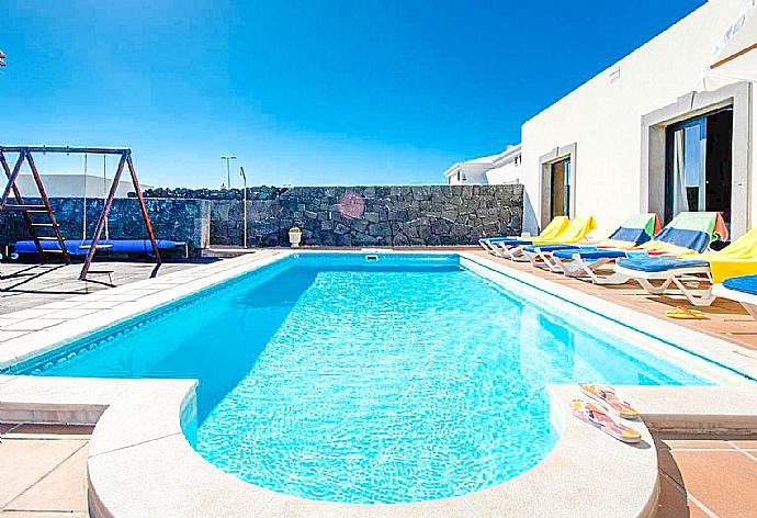 Pool area with sunbeds and parasol . - Villa Calma . (Photo Gallery) }}