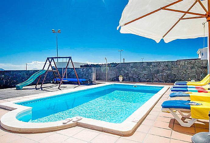 Pool area with sunbeds and parasol . - Villa Calma . (Photo Gallery) }}