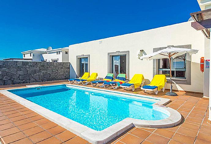 Pool area with sunbeds and parasol . - Villa Calma . (Photo Gallery) }}