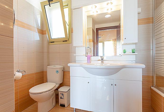 En suite bathroom with bath and overhead shower . - Villa Apollo . (Fotogalerie) }}