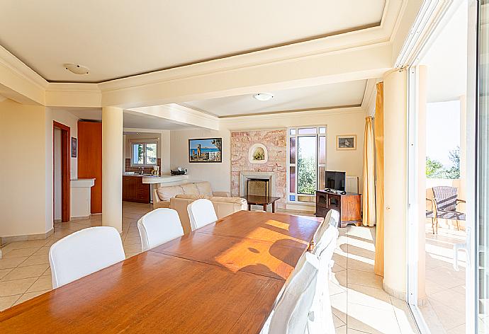 Open-plan living room with sofas, dining area, kitchen, ornamental fireplace, A/C, WiFi internet, satellite TV, DVD player, and balcony access . - Villa Asimenia . (Fotogalerie) }}