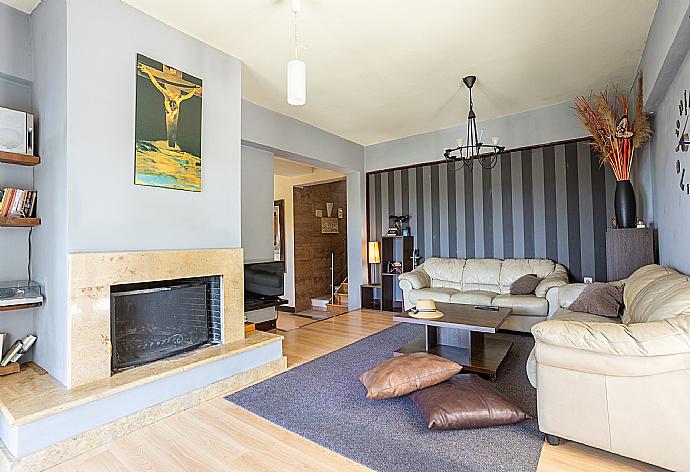 Open-plan living room with sofas, dining area, kitchen, ornamental fireplace, WiFi internet, and satellite TV . - Villa Mavrikia . (Galleria fotografica) }}