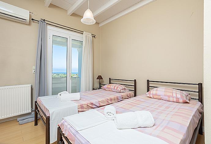 Twin bedroom with A/C and balcony access . - Villa Mavrikia . (Photo Gallery) }}