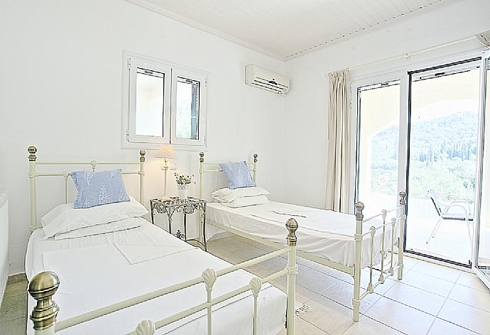 Twin bedroom with A/C, en suite bathroom and terrace access . - Villa Eleonas . (Photo Gallery) }}