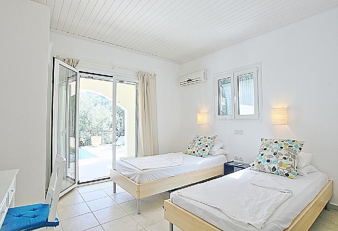 Twin bedroom with A/C, en suite bathroom and terrace access . - Villa Eleonas . (Photo Gallery) }}