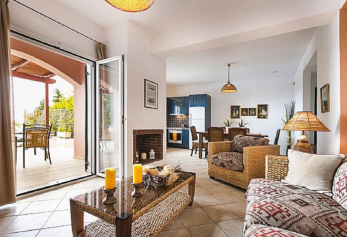 Open-plan living room with sofas, dining area, kitchen, ornamental fireplace, A/C, WiFi internet, satellite TV, DVD player, and terrace access . - Villa Thalia Katerina . (Galería de imágenes) }}