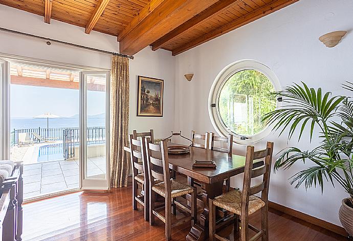 Open-plan living room with sofas, dining area, kitchen, ornamental fireplace, A/C, WiFi internet, satellite TV, and terrace access with sea views . - Villa Elpida . (Fotogalerie) }}