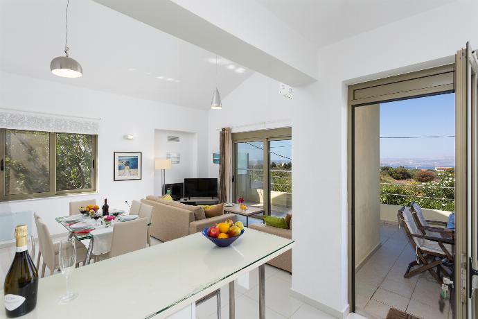 Open-plan living room with sofas, dining area, kitchen, ornamental fireplace, A/C, WiFi internet, and satellite TV . - Villa Litsa . (Fotogalerie) }}