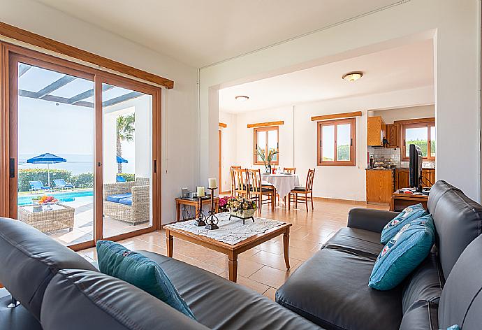 Open-plan living room with sofa, dining area, kitchen, A/C, WiFi internet, satellite TV, and sea views . - Villa Pelagos . (Fotogalerie) }}