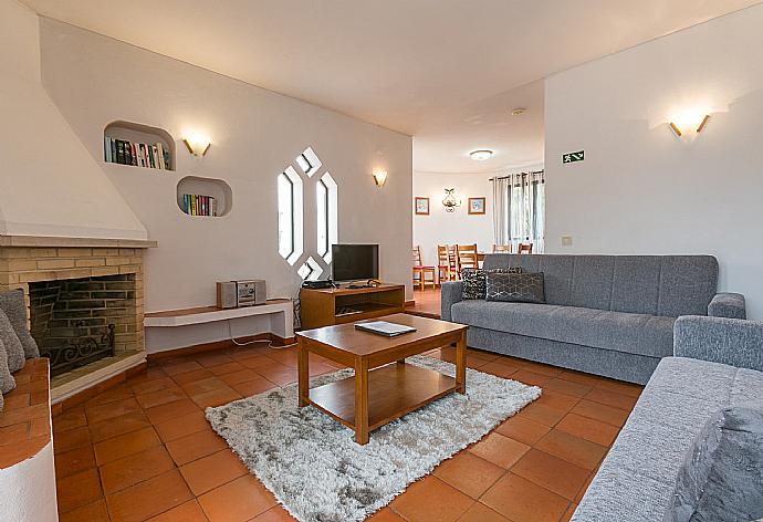 Living room with sofas, dining area, ornamental fireplace, WiFi internet, satellite TV, and DVD player . - Villa Coelho . (Galería de imágenes) }}