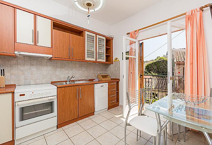 Equipped kitchen, dining area, and balcony access . - Anna Apartment . (Photo Gallery) }}