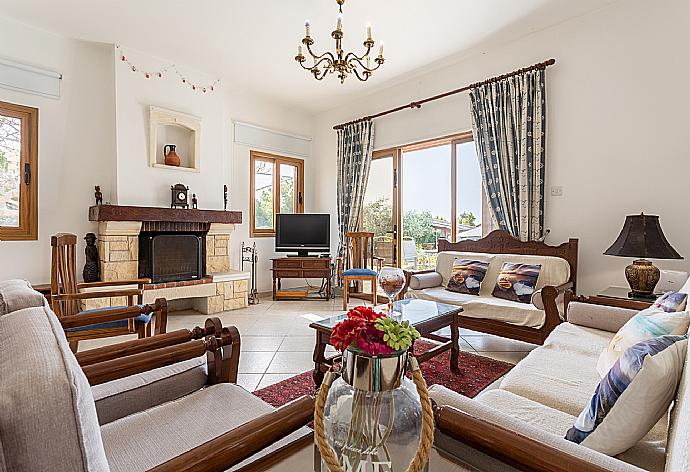 Open-plan living room with sofas, dining area, kitchen, ornamental fireplace, A/C, WiFi internet, and satellite TV . - Villa Xenios Dias . (Fotogalerie) }}