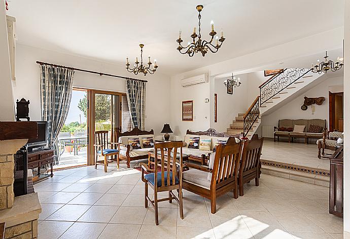 Open-plan living room with sofas, dining area, kitchen, ornamental fireplace, A/C, WiFi internet, and satellite TV . - Villa Xenios Dias . (Fotogalerie) }}