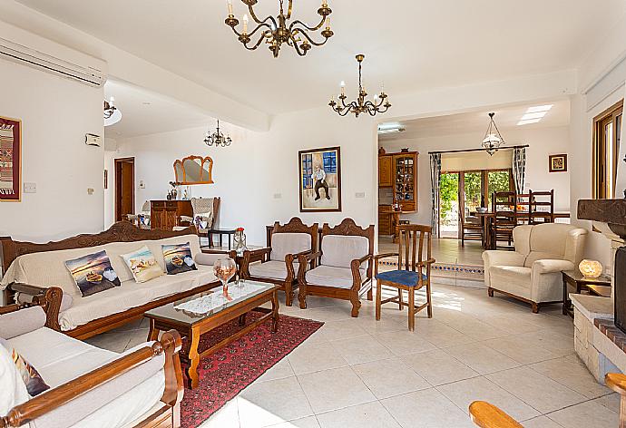 Open-plan living room with sofas, dining area, kitchen, ornamental fireplace, A/C, WiFi internet, and satellite TV . - Villa Xenios Dias . (Fotogalerie) }}