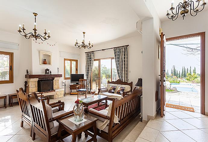 Open-plan living room with sofas, dining area, kitchen, ornamental fireplace, A/C, WiFi internet, and satellite TV . - Villa Xenios Dias . (Fotogalerie) }}