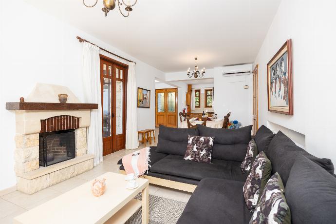 Open-plan living room with sofa, dining area, kitchen, ornamental fireplace, A/C, WiFi internet, satellite TV, and sea views . - Villa Ariadne . (Photo Gallery) }}