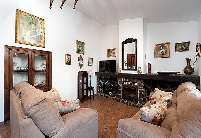 Living room with sofas, dining area, ornamental fireplace, A/C, WiFi internet, satellite TV, DVD player, and terrace access . - Villa Maravillas . (Photo Gallery) }}