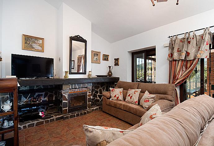 Living room with sofas, dining area, ornamental fireplace, A/C, WiFi internet, satellite TV, DVD player, and terrace access . - Villa Maravillas . (Photo Gallery) }}