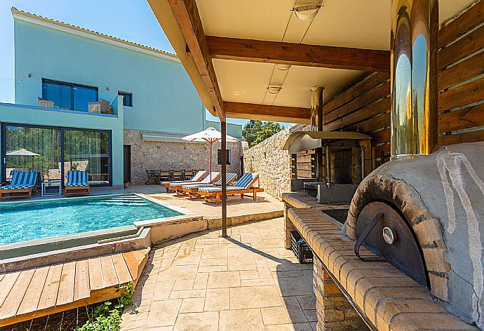 Sheltered terrace area with BBQ and wood-fired oven . - Villa Eleanna . (Galleria fotografica) }}