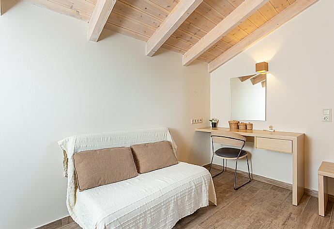 Twin bedroom with en suite bathroom, sofa, desk, and A/C . - Villa Eleanna . (Photo Gallery) }}