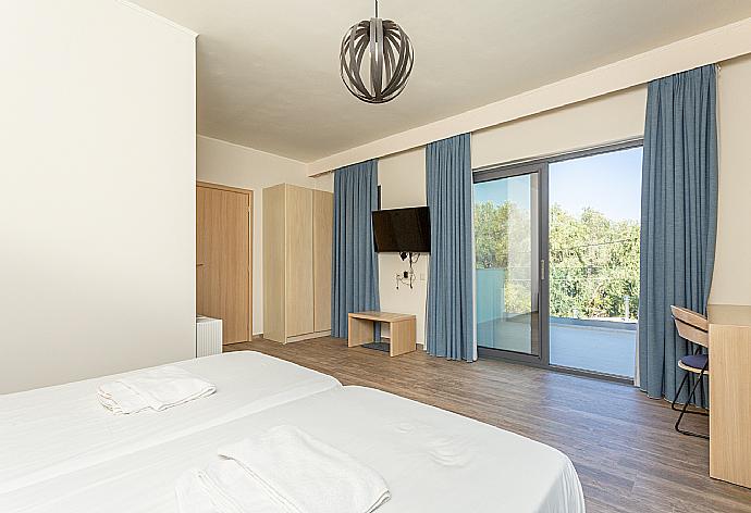 Twin bedroom with en suite bathroom, A/C, TV, desk, and upper terrace access . - Villa Eleanna . (Галерея фотографий) }}