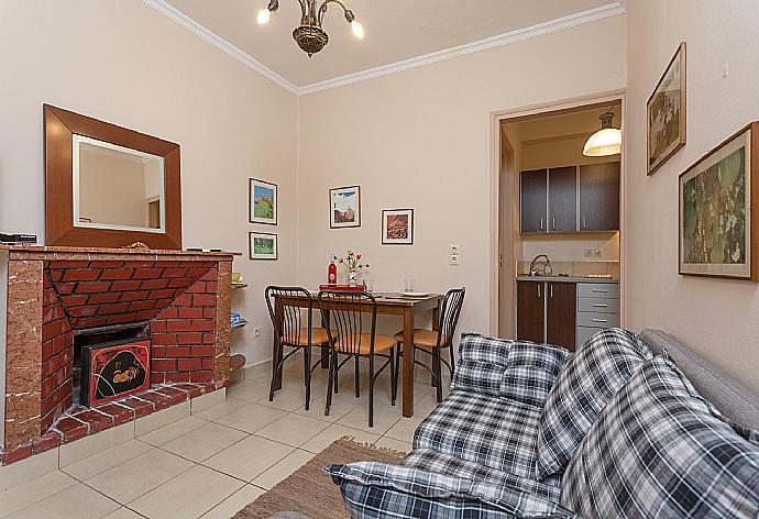 Living room with sofa, dining area, ornamental fireplace, A/C, WiFi internet, satellite TV, and DVD player . - Foteini Apartment . (Galleria fotografica) }}